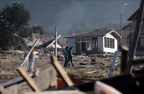 Dos hombres caminan entre las casas arruinadas hoy-lunes 8 de marzo de 2010-en la localidad de Iloca