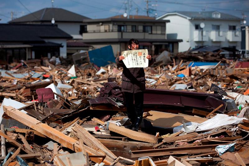 Fotografía del japonés Yasuyoshi Chiba, ganadora del primer premio en la categoría de "Gente en las Noticias", muestra a Chieko Masukawa mientras levanta el certificado de graduación de su hija que ha encontrado entre los escombros tras el tsunami que arrasó la ciudad de Higashimatsushima, Japón.