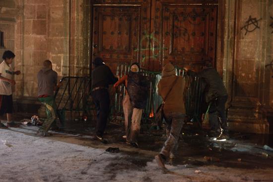 Grupo incendia puerta de Palacio Nacional al finalizar marcha por 43 jóvenes