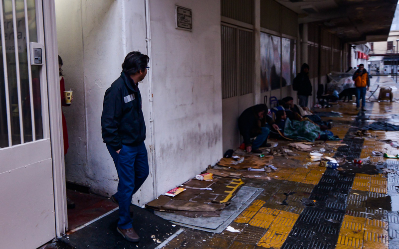 06 AGOSTO de 2015/ SANTIAGO El Ministro de Desarrollo Social, Marcos Barraza(c), ovserba  a loas personas en situación de calle que viven en las afueras del albergue Víctor Jara,  al cual asistió ara   entregar un  balance de las medidas de emergencia por frente de mal tiempo. FOTO: PABLO ROJAS MADARIAGA/AGENCIAUNO