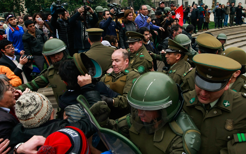 27 de Agosto 2015/SANTIAGO Un manifestante le quira la gorra a un oficial de carabineros en una manifestación frente a La Moneda. Simpatizantes de Mapuches y Camioneros y agricultores se enfrentaron en la Plaza de la Constitución. FOTO: JORGE FUICA/AGENCIAUNO