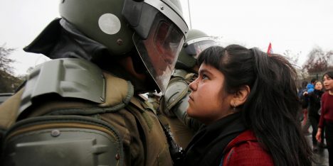 A demonstrator looks at a riot policeman during a protest marking the country's 1973 military coup in Santiago, Chile September 11, 2016. REUTERS/Carlos Vera FOR EDITORIAL USE ONLY. NO RESALES. NO ARCHIVE.     TPX IMAGES OF THE DAY      CHILE-PROTEST/