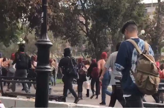 Estudiantes corretearon a encapuchados que intentaban enfrentarse a Carabineros durante marcha feminista