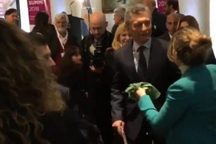 Mujer entrega pañuelo verde a Mauricio Macri a horas de votación por el aborto libre en Argentina