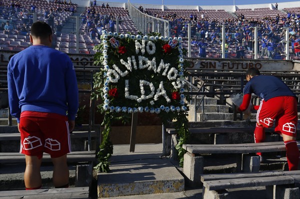Jugadores de la Universidad de Chile dejan flores en el memorial de los Detenidos Desaparecidos en el Estadio Nacional
