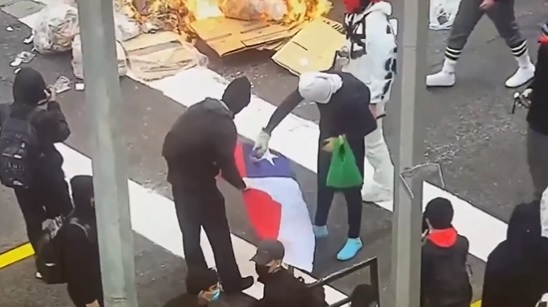 Manifestantes queman bandera chilena en protesta al exterior del Instituto Nacional