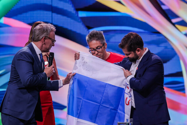Presidente Gabriel Boric dona bandera de Universidad Católica firmada a la Teletón